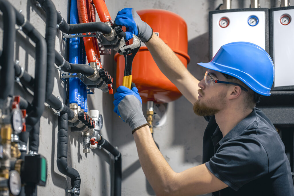 man installs heating system house checks pipes with wrench